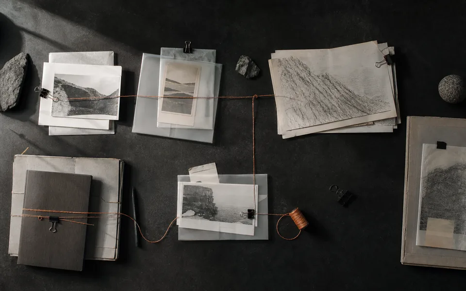 Research materials arranged in connected groups across a dark worktable.